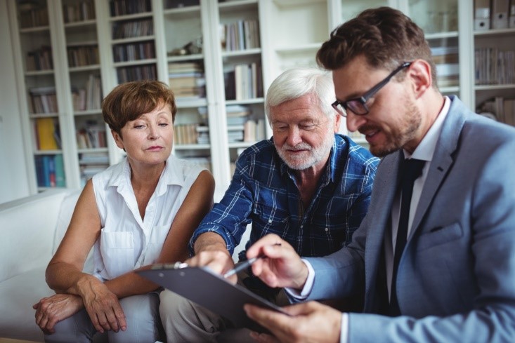 Older gentleman and daughter working on his estate plan with a lawyer