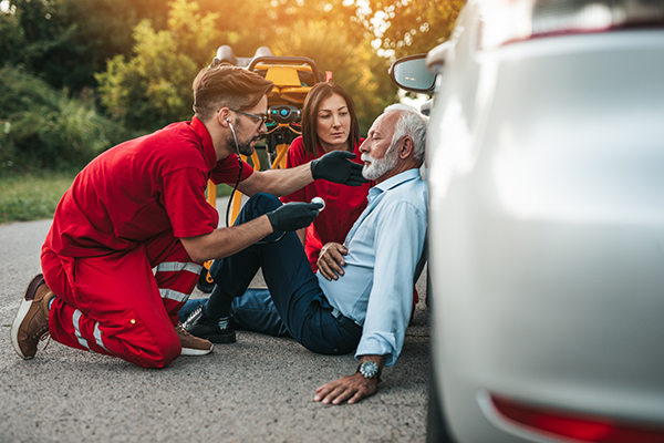 Emergency medical personnel tend to a crash victim’s wounds