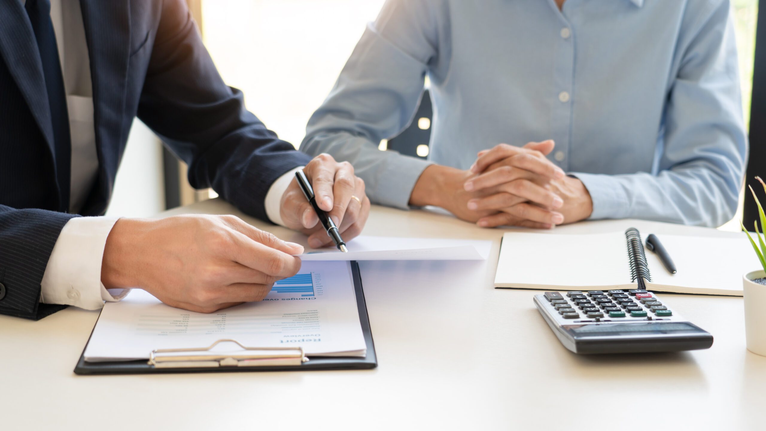 An image of two people consulting paperwork.