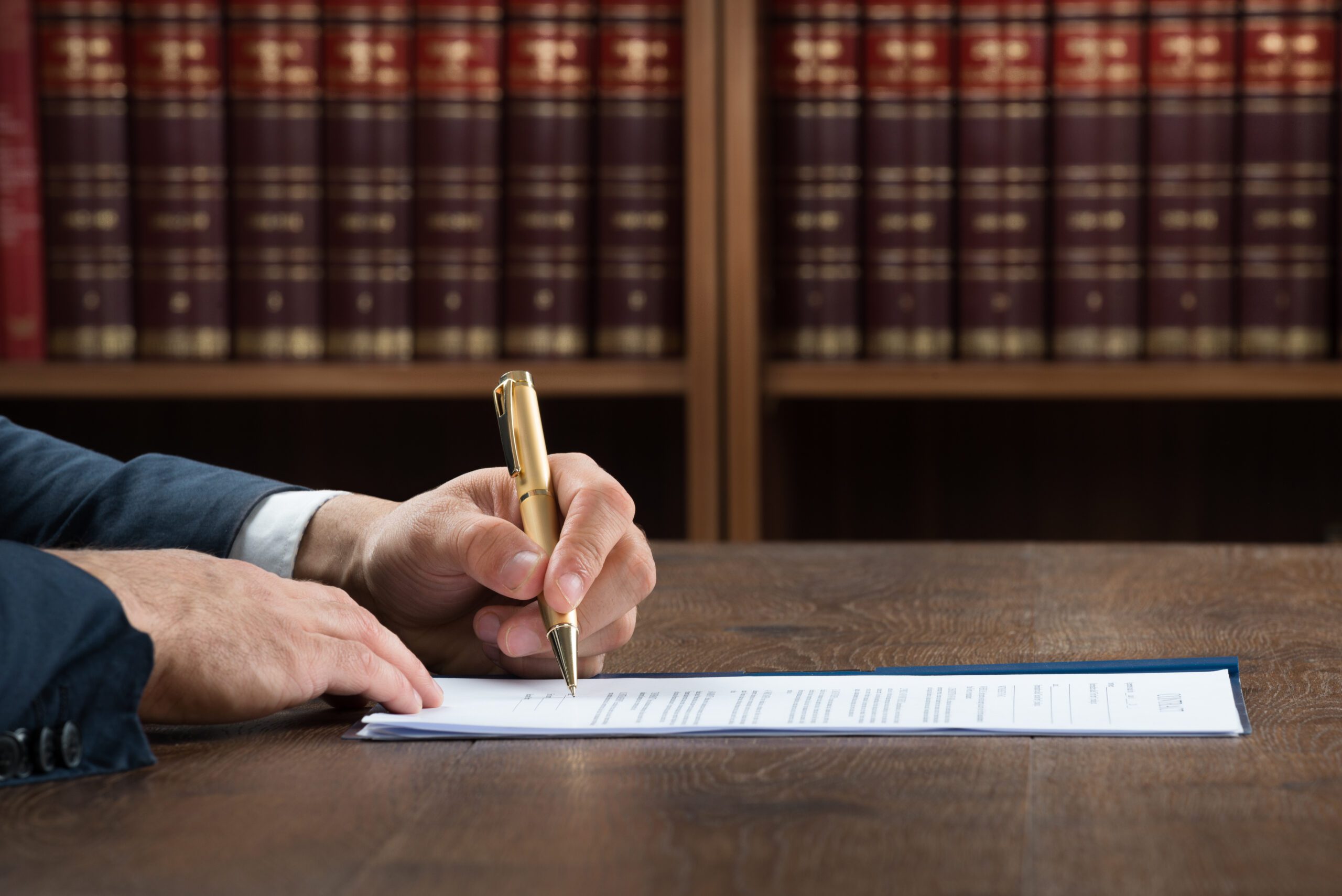 A lawyer sitting at a table, doing paperwork.